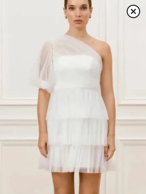 Vit asymmetrisk tyllklänning - Säljer min fina studentklänning! Använd en gång på min student. Inga fläckar och som helt ny! Köpte den ny för 3500 men säljer för 2500! 