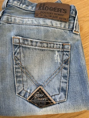 Vintage/ Y2K Roy Rogers jeans W31/L30  - Säljer ett par ljusblå jeans från Roy Rogers med slitna detaljer och raka ben. Jeansen har klassiska fickor, kontrastsömmar och en snygg patch på bakfickan. Perfekta för en avslappnad och trendig look. Midja: 38 cm,  ytterlängd: 107 cm, innerbenslängd: 80 cm 