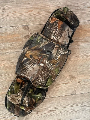 Camo axelväska med flera fack - Axelväska i camouflagemönster med flera praktiska fack och justerbar axelrem. Väskan har robusta dragkedjor och spänne, perfekt för dig som gillar outdoor eller streetwear. Tillverkad i slitstarkt tygmaterial och har mesh på baksidan. Swag 