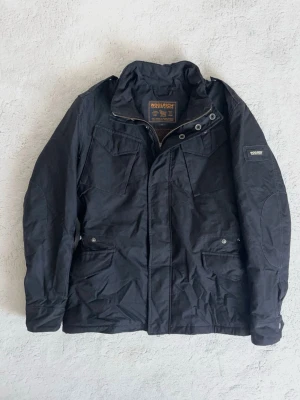 Woolrich Field Jacket - Stilren Vårjacka från Woolrich! Fint skick, inga defekter. Storlek M, modellen är ca 182 cm. Kontakta mig för fler frågor och funderingar!
