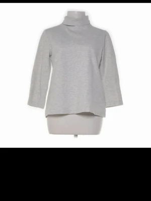 Ljusgrå polotröja från H&M - Säljer en ljusgrå polotröja från H&M med trekvartsärmar och rak passform. Tröjan har en hög polokrage och är tillverkad i mjukt, tunt material som passar perfekt till lager-på-lager. Enkel och stilren design. Liten i storlek så skulle säga strl xs-d