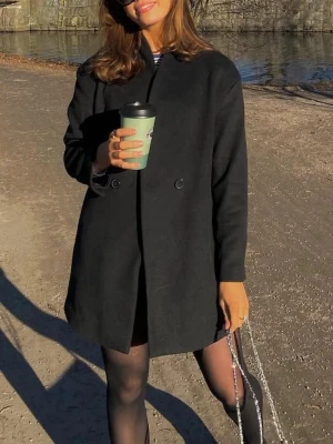 Svart rak ullkappa dubbelknäppt - Svart kortare kappa från Mango i ullblandning med rak passform och dubbelknäppning framtill.   Superfin i kvaliten och knappt använd! Inköpt för ca 1000kr på Mango. Skulle säga passar både XS-S   Material: 56% polyester, 30% recycled wool, 5% wool, 3% acrylic, 3% polyamid, 3% 3% viscose