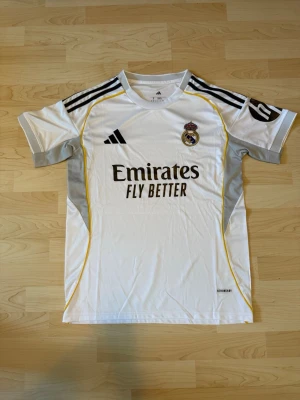 Real Madrid Hemma Kit 2025/26 - Stilren fotbollströja i helt nytt skick. Tröjan är inte använd en endaste sekund.