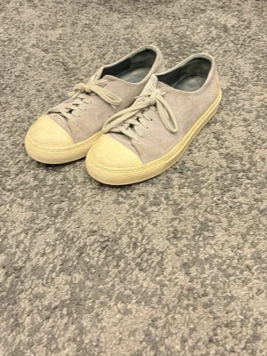 Grå låga sneakers från Arigato - Snygga låga sneakers från Arigato i grått tyg med beige gummisula och tåparti. Klassisk design med snörning och enkel siluett som passar till det mesta. Sköna att bära och lätta att matcha med olika outfits. Pris kan diskuteras.