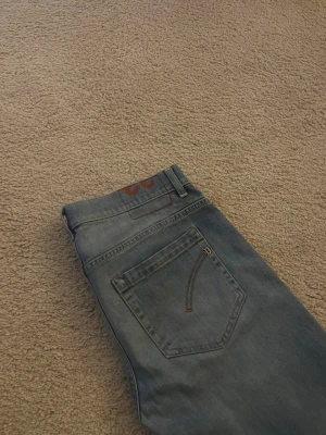Dondup jeans  - Dondup jeans – slim fit, blå tvätt Snygga Dondup-jeans i blå tvätt med lätt slitning för en avslappnad men stilren look. Slim fit-modell som sitter snyggt utan att vara för tight. Klassisk 5-ficksdesign med Dondup-detalj på bakfickan. Lite uppsyd