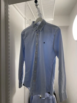 Ljusblå skjorta från Morris - Klassisk ljusblå skjorta med lång ärm och vita knappar framtill. Nypris: 1299kr. Skjortan är från Morris och har en liten broderad logga på bröstet och en stilren krage. Perfekt för dig som gillar enkel och clean stil. Endast seriösa köpare. Kan sänka pris vid snabb affär!