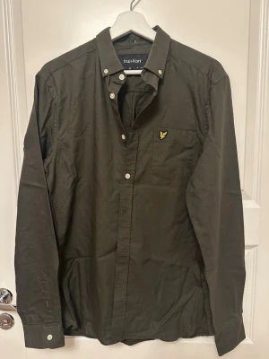 Mörkgrön skjorta från Lyle & Scott - Stilren mörkgrön skjorta från Lyle & Scott med klassisk button-down krage.