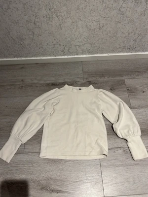 Vit stickad tröja med puffärmar -  vit stickad tröja med långa puffärmar. Använd fåtal gånger. Stl XS