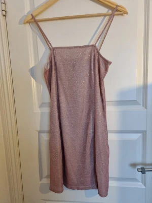 Glittrig miniklänning - Säljer denna glittriga klänning från H&M i strl m. Inga defekter förekommer!