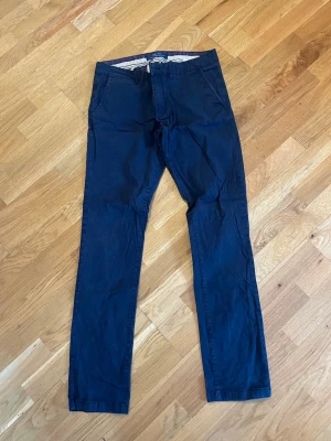 Mörkblå chinos från zara - Snygga mörkblå chinos från zara med klassisk rak passform och diskreta fickor både fram och bak. Tillverkade i mjukt bomullstyg med en stilren look som passar perfekt till en avslappnad men ändå uppklädd stil.
