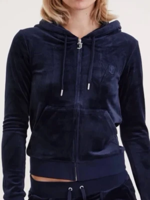 Mörkblå velour hoodie med dragkedja - Mjuk och skön mörkblå hoodie i velour med dragkedja framtill, huva med snören och stor magficka. Perfekt för en avslappnad och trendig look. Diskret broderad logga på bröstet och ribbade muddar vid ärmar och midja.
