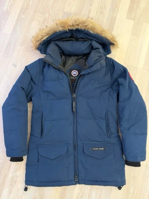 Canada Goose Trillium parka navy XS - Canada Goose Trillium Parka i navy, storlek XS (dam, regular fit). Mycket fint begagnat skick med bevarad pals, dragkedja och tyg. Klassisk och eftertraktad modell som håller värmen riktigt bra. Made in Canada Arctic Tech® Original coyote-pals Alla etiketter finns kvar (se bilder) Notera: mindre slitage vid ena fickkanten (visas pă bild). Diskret, påverkar inte funktion eller användning. Pris justerat därefter. Säg till om du vill ha mått eller fler bilder. Snabb affar får billigare!
