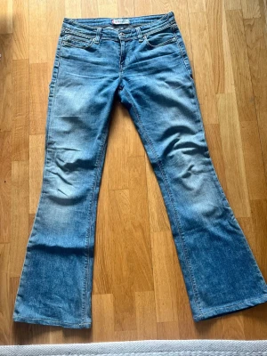 Utsvängda Levis Jeans - Säljer dessa supersnygga Levis jeans som är bootcut och i en perfekt blå färg. Skicket är mycket bra, men säljer pga att de blivit för små!  Midjemått: 38 cm Innerbenslängd: 75 cm