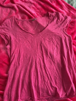 Rosa t-shirt från me&i - Enkel och snygg rosa t-shirt från me&i i storlek L. T-shirten har korta ärmar, rund halsringning och är gjord i mjuk bomull. Perfekt till jeans eller shorts för en avslappnad look. Säljer pågrund för stor för mig!