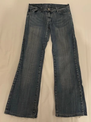 Blå Victoria Beckham Jeans - Blå lågmidjade vida Victoria Beckham jeans. Lite slitna men ändå snygga. Små hål vid ena bakfickan och två i skrevet, borde gå att sy ihop enkelt då de är väldigt små och sitter på ställen där de inte syns så mycket. Antingen avklippta eller uppsprättade nertill, inte jag som gjorde. MIDJEMÅTT: 38cm INNERBENSLÄNGD: 72cm