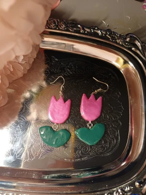Tulpan örhängen - Handgjorda örhängen med tulpaner. Blomman är schimrig  One of a kind Denna är Handgjord av lera därav priset. Om intresse fins kan jag göra flera