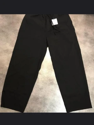 Pull & Bear Svarta byxor, storlek L - Säljer ett par svarta mjukisbyxor från Pull&Bear i storlek L. Byxorna har resår i midjan med dragsko och raka, vida ben. Perfekta för chill dagar eller när du vill ha det extra bekvämt. Tillverkade i mjukt material.