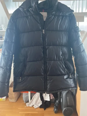 Svart moncler jacka  - Säljer en svart moncler jacka. Riktigt varm och go så perfekt för kalla vinterdagar. Men den kan även användas året om. Riktigt snygg o lite schysstare jacka. Tagg och qr koden funkar!