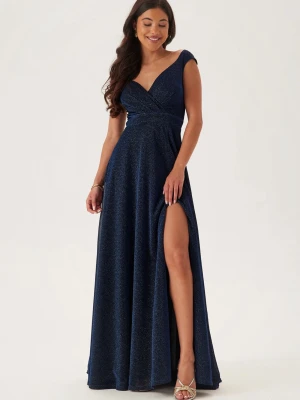 Marinblå glittrig långklännig - Balklänning från bubbelroom i storlek xxs passar mig som är 165 cm och har storlek s i vanliga fall går ända ner till fötterna. Den har en slits men sitter inte högt upp