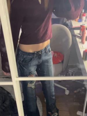 Blå bootcut jeans med broderier - Säljer ett par blå bootcut jeans med coola broderade detaljer på benen. Jeansen har låg midja och klassisk femficksdesign. Jag är 173cm lång och dem går ner till mellan vaden och golvet så ungefär storlek 36/34. Skriv om ni har nå frågor🩷