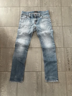 Nudie jeans - Blåa Nudie jeans storlek W28 L32. Feta fades och slitningar. Hör gärna av dig vid frågor eller funderingar.