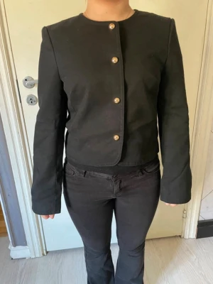 Svart kavaj med guldknappar - Säljer denna tröja i XS från HM då jag inte använder den längre, köpte den för typ 1 år sen och har inte använt den så mycket. Den är liten i storleken skulle jag säga så den passar dig som har XXS. Skriv vid frågor eller nåt!