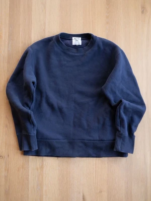 Mörkblå sweatshirt från Jackman - En stilren mörkblå sweatshirt från Jackman i storlek M, men sitter som S. Tröjan har rund halsringning, ribbade muddar vid ärmslut och nederkant samt mjuk insida. Perfekt för en avslappnad och snygg look.