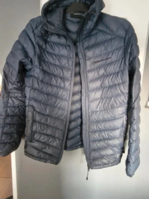 blå dunjacka med huva peak performance  - Hej! Säljer min blå jacka från peak Performance, är u topp skick har en liten skada vid texten som ni ser i bild 3. Köpte för 2399 från deras hemsida säljer endast 330. Perfekt till hösten o vintern som kommer🍂🍁⛄️❄️