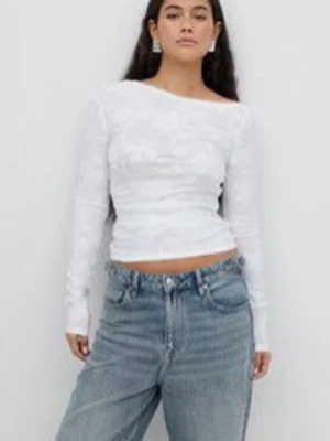 Vit mesh topp med lång ärm - Trendig vit mesh topp med långa ärmar och figurnära passform. Toppen har en lätt transparent look och rundad halsringning, perfekt att styla med jeans eller kjol för en cool och modern vibe.
