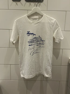 Vit t-shirt med tryck  - Vit t-shirt med ett snyggt blått tryck Storlek: XS Passform: Normal Skick: bra, lite gulaktig vid armhålorna Märke: Laidbclothing Nypris: 400 SEK Skickas inom 24h😁