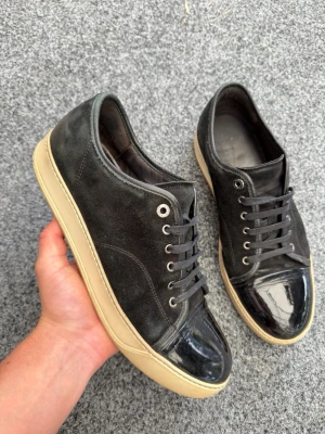 Lanvin uk10 svart - Säljer dessa sjukt snygga svarta lanvin cap toe sneakers! Uk10/44-45. Skick 8,5/10 riktigt fint skick, lite skada på cap toe men det är normalt, inget super märkvärdigt. Nypris 5200kr. Lanvin dustbag ingår. Fraktar inom 24H. Kan gå ner i pris vid snabb affär! Mvh 🤩