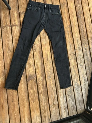 Svarta slim fit jeans - Säljer ett par svarta slim fit jeans med klassisk fyrficks och silverfärgade nitar. Jeansen har normal midja och raka ben. Perfekta för en avslappnad och stilren look.
