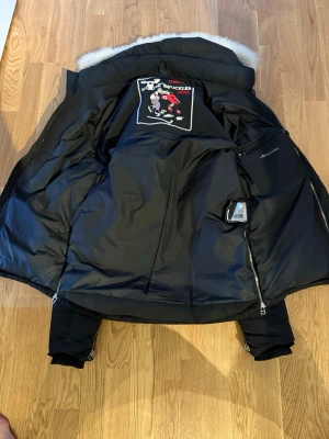 Svart dunjacka från Moose Knuckles - Säljer en exklusiv dunjacka från Moose Knuckles. Nypris ca 14 990 kr. Jackan är i mycket bra skick och sparsamt använd.  • Färg: Svart • Äkta päls på huvan • Varm och rejäl – perfekt för kalla vintrar • Stilren modell med klassisk metallogga på ärmen • Alla dragkedjor och detaljer i fint skick  En riktigt snygg och varm kvalitetsjacka som håller i många år.  Pris: 2000 kr (kan diskuteras vid snabb affär)  Skicka meddelande vid intresse 😊