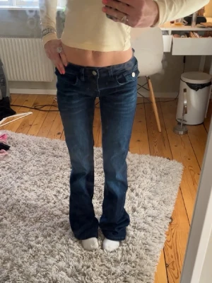 Mörkblå bootcut jeans med låg midja - Säljer ett par oanvända bootcut jeans med låg midja