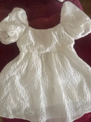 Vit puffärmad klänning - Supersöt vit klänning med puffärmar och strukturerat tyg. Klänningen har en vid kjol och fyrkantig ringning både fram och bak. Perfekt för studenten. 💗