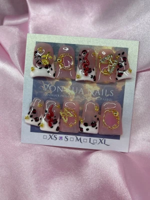 DolceRouge (S); Medium Duck Nails - Unika handgjorda press-on naglar  i en cool duck nail med animal print med svart/röda fläckar, ljusrosa fransk manikyr, röda ormar  och guldfärgade dekorationer. Naglarna har en kort duck nail form och en nuderosa bas. Perfekta för dig som vill sticka ut med en kreativ och trendig look.S: 15 mm, 11,5 mm, 12 mm, 11 mm, 9 mm 