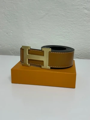 Herme's Bälte (Vändbar) - Bältet är vändbart och går att bäras åt.båda sidorna. Helt nytt aldrig använd. Storlek 110. Snabb frakt. Endast bälte.