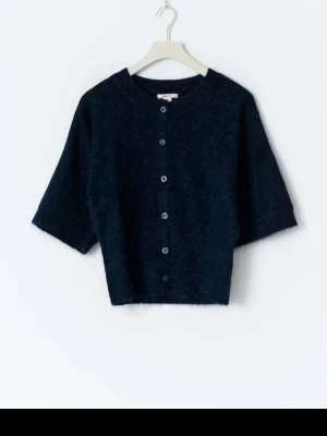 Marinblå stickad tröja - kortärmad kofta med knappar, har andvänt den två gånger och den är som ny. Storleken är 158/164 och är som XS. 