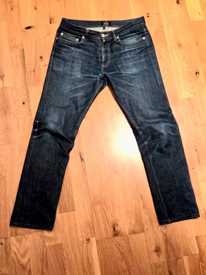 Mörkblå jeans från A.P.C. - Snygga mörkblå jeans från A.P.C. i klassisk rak modell. Jeansen har fem fickor, silverfärgade nitar och kontrastsömmar. Tillverkade i kraftig denim som ger en stilren och tidlös look. Perfekta för dig som gillar minimalistisk stil.