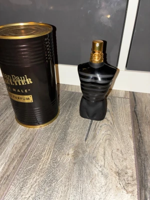 Jean Paul Gaultier Le Male Parfum - Jean Paul Gaultier Le Male Parfum i en svart, matt flaska formad som en manlig torso med gulddetaljer. Parfymen kommer med sin ikoniska svarta metallburk med guldfärgade detaljer. En klassisk och elegant doft för dig som vill sticka ut. Mycket kvar knappt använd