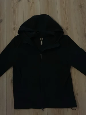 Svart windbreaker från Colmar - Riktigt snygg svart windbreaker från Colmar med huva och hel dragkedja framtill. Jackan har en minimalistisk design och är perfekt för blåsiga dagar. Storleken är 48. Tillverkad i ett lätt och funktionellt material som passar till många olika stilar. Köpt från zalando och säljer för att den är för liten. Använd endast ett fåtal gånger! Hör av er vid funderingar!