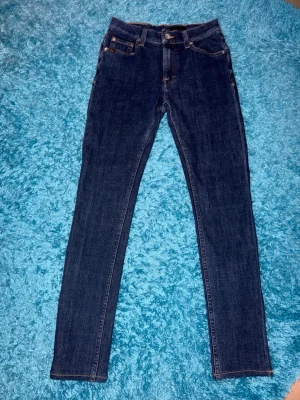 Tiger of Sweden jeans - Säljer ett par mörkblå skinny jeans från Tiger of Sweden . Jeansen har normal passform i midjan och smala ben som sitter tight hela vägen. Storlek 29/30