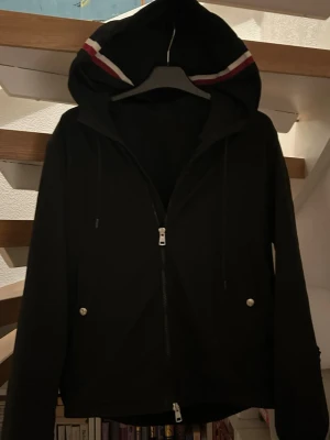 Svart vindjacka med huva - Hej, Jag säljer då min fina Moncler Windbreaker eftersom jag inte då passar i den lika bra längre! Skit bra skick, väldigt fin i färgen och har fått många komplimanger för den. Jackan har stor efterfrågan. Den är perfekt i början av sommaren som kommer. Rekommenderar starkt! Jackan passar i längd 165-175.