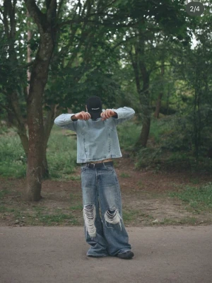 Baggy slitna jeans med stora hål - Säljer ett par riktigt baggy jeans i ljusblå denim med stora slitningar och hål på båda benen. Jeansen har extra vida ben och en avslappnad passform som ger en cool streetwear-vibe. Perfekta för dig som gillar oversized och edgy stil.
