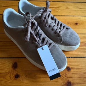 Beige mocka sneakers Selected Homme - Eleganta och sofistikerade mocka selected homme skor, oanvända. Säljer pgd fel storlek. Nypris: 1200