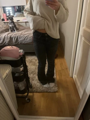 Svarta bootcut jeans - Säljer ett par svarta bootcut jeans med klassisk femficksdesign och låg midja. Jeansen har en lätt utsvängd passform nedtill och är perfekta för dig som gillar en avslappnad men ändå trendig look. Materialet känns mjukt och följsamt.