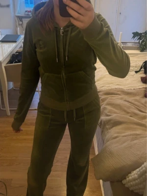 Juciy Couture Set - Säljer ett jättefint Juicy Couture set i färgen Dark Moss. Använt fåtal gånger därav inga tecken på användning eller några defekter. Tröjan är i storlek S och byxorna i Xs, båda passar någon som har storlek xs-m då materialet är strechigt med en tajtare passform! Ordinarie pris - 1200+1100 så 2300kr