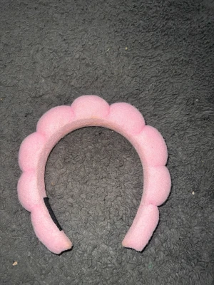 Puffigt rosa diadem i tyg - Säljer ett gulligt puffigt diadem i ljusrosa tyg. Diademet har en vadderad, bubblig form som ger en trendig och lekfull look. Perfekt accessoar för att lyfta vilken outfit som helst med en söt touch.