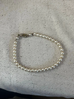 Klassiskt pärlarmband med metallås - Snyggt armband med vita runda pärlor och ett enkelt metallås. Perfekt för dig som gillar stilrena accessoarer med en tidlös känsla. Passar till många olika looks och är lätt att matcha med andra smycken.