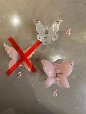 Vit och rosa fjärilshårklämma med stenar - Säljer två hårklämma i form av en fjäril i vit och rosa med små glittriga stenar på vingarna. 1 för 70 2 för 110